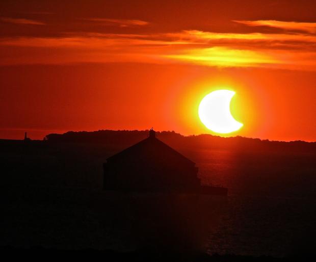 Partial solar eclipse at sunset. Buffalo Harbor. Photo by Jay Burney.
