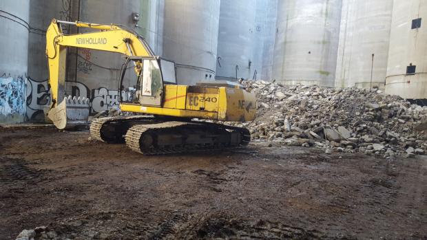 Inside Paladino’s Gelmac silos, an excavator moves illegally dumped demolition waste from a North Street parking ramp.
