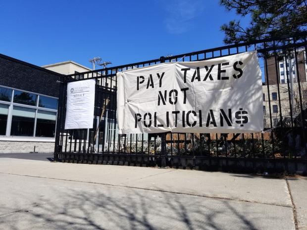 A banner dropped Thursday afternoon at the northeast corner of Elmwood and Bryant. Photo by Johanna C. Dominguez.
